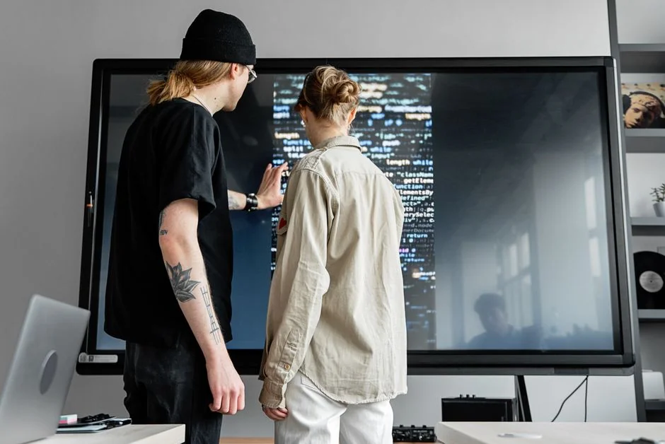 A website wireframe on a macbook screen on an office desk.